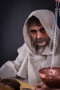 Monk alchemist is engaged in science, writing ancient manuscripts on birch bark