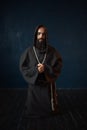 Monk in black robe with hood kneeling and praying Royalty Free Stock Photo