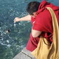 Monk feeding fish