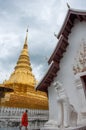 Monk and golden pagoda, Phrathat Chaehaeng, Nan, Thailand