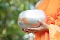 Monk with hand holding give alms bowl which came out of the offerings in the morning at Buddhist temple, Culture Heritage Site tra