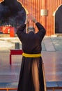 Monk praying with raised hands in a buddhist temple yard in Beijing, China. Seen from behind Royalty Free Stock Photo