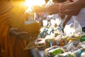 Monk receiving food and items offering from people