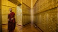Monk in red robes prays inside temple