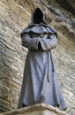 A monk sculpture over a brick wall at old town city