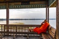 The monk seating on the U Bein Bridge at Peaceful lake landscape in Mandalay, Myanmar