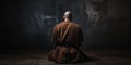 monk sits in a dark room, meditating and seeking spiritual enlightenment with his back turned