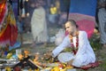 Monk sitting near open fire preparing to conduct vedic wedding ceremony