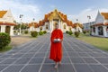 Monk waiting to collect alms, at the Marble Temple, Bangkok