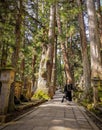 Monk walking on the long path in the Okunoin cemetery towards the mausoleum of Kobo Daishi
