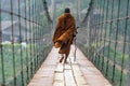 A monk with a walking stick Walk on a wooden suspension bridge in a small village in Mae Hong Son