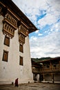 A monk walks the courtyard of the Punakha Fortress Monastery, Paro, Bhutan