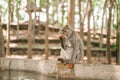 Monkey sitting on the edge of the pool and eats rambutan. Feeding monkeys in the monkey forest Park in Ubud