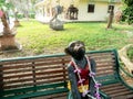 Monkey Statue Sitting Lonely on The Long Chair in The Garden