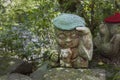 Monkey - symbol of japanese horoscope. Jizo stone statue wearing knitted and cloth hats.