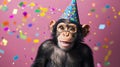 Monkey wearing a fun party hat with confetti scattered around, having Royalty Free Stock Photo