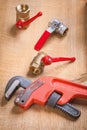 Monkey wrench and plumbing fixtures on wooden board Royalty Free Stock Photo