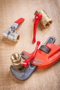 Monkey wrench with plumbing fixtures on wooden board Royalty Free Stock Photo