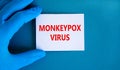 Monkeypox virus symbol. Concept words Monkeypox virus on white card. Doctor hand in blue glove with white card. Medical and