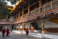 Monks around the large white-washed stupa and bodhi tree in the first courtyard of Punakha Dzong, Bhutan