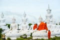 Monks dressing one of White Buddha Image with robes