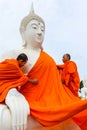 Monks dressing one of White Buddha Image with robes
