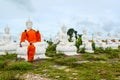 Monks dressing one of White Buddha Image with robes