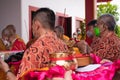 The monks helping the visitors prepare the offerings in the altar