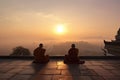 monks meditating in quiet courtyard, with view of the sunrise