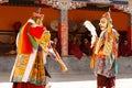 Monks perform a masked and costumed sacred dance of Tibetan Buddhism, another monks play ritual music during the Cham Dance Festiv