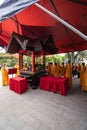 The monks standing in a circle at the bottom of a red dome for an altar