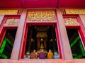 Monks with three colors robe pay respect to emerald Buddha sculpture at Wat Phra Kaeo - Chiang Rai, Thailand Royalty Free Stock Photo