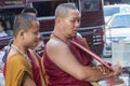 Monks waiting for alms on the early morning market in Chiang Mai, Thailand