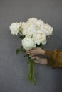 Mono beautiful bouquet of lush white peonies in woman`s hands on Royalty Free Stock Photo