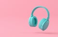 Monochromatic blue wireless headphone on pink background with copy space
