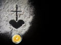 Lent Season,Holy Week and Good Friday concepts - Image of ash in shape of heart and cross with candle light on dark background Royalty Free Stock Photo