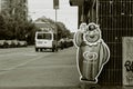 Monochromatic image of a street scene with a focus on the GB Glace mascot.