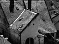 Monochrome aerial closeup view of quaint old sloped clay roofs in urban setting. chimneys and antennas