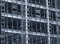 Monochrome blue tinted view of a large building development under construction with steel framework and girders Royalty Free Stock Photo