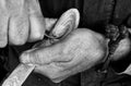 Monochrome close-up view of Working hands - a woodcarver is working on wooden spoon with his carving knife