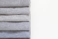 Grey clean ironed folded clothing with copy space on white background