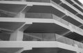 Monochrome detail shot of a facade of a skyscraper. You can see surrounding balconies and large glass windows