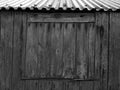 Blocked up window with weathered planks on a rustic shed or farmhouse outbuilding with a tin roof Royalty Free Stock Photo