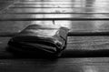 Monochrome image, dropped leather man`s wallet on wood floor