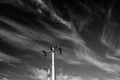 Monochrome image, electricity pylon against dark  sky with white clouds Royalty Free Stock Photo