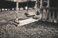 monochrome image empty swing at the playground in summer, horizontal