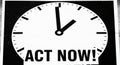 A monochrome image features a large clock face with black minute and hour