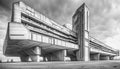 large concrete brutalist apartment building surrounded by other housing