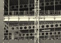 Monochrome image of a large construction site with steel framework and girders with fences and building hoist Royalty Free Stock Photo