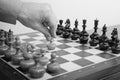 Monochrome image of man's hand making first first move in chess game. White starts the game Royalty Free Stock Photo